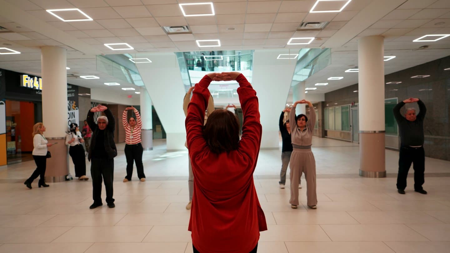 Adults stretching in a bright, modern community center.